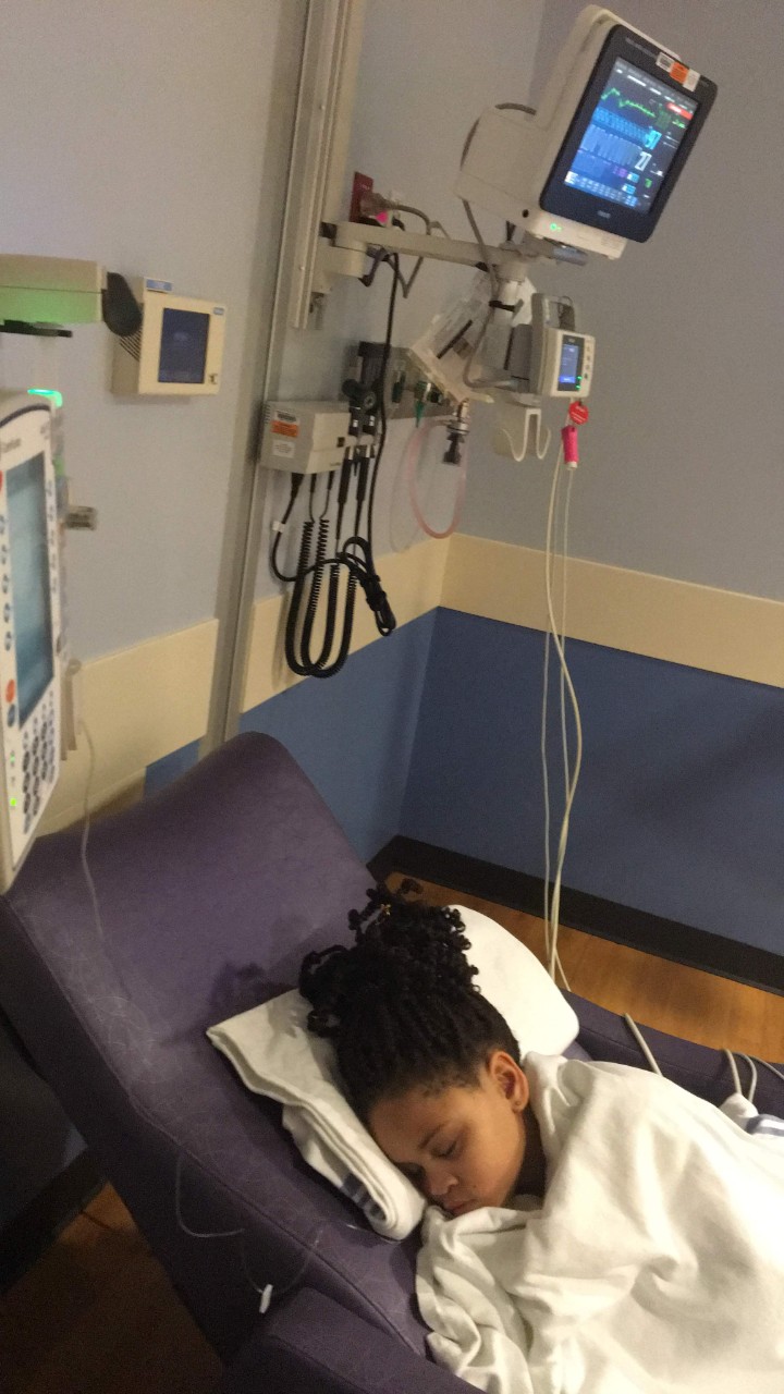 Journey sleeping in a hospital bed, receiving treatment for her sickle cell disease